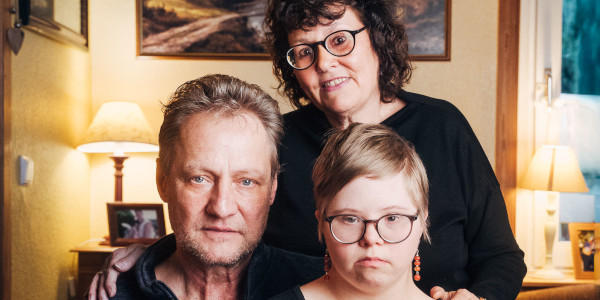 Ein Familienbild mit Vater, Mutter und Kind in einem Wohnzimmer