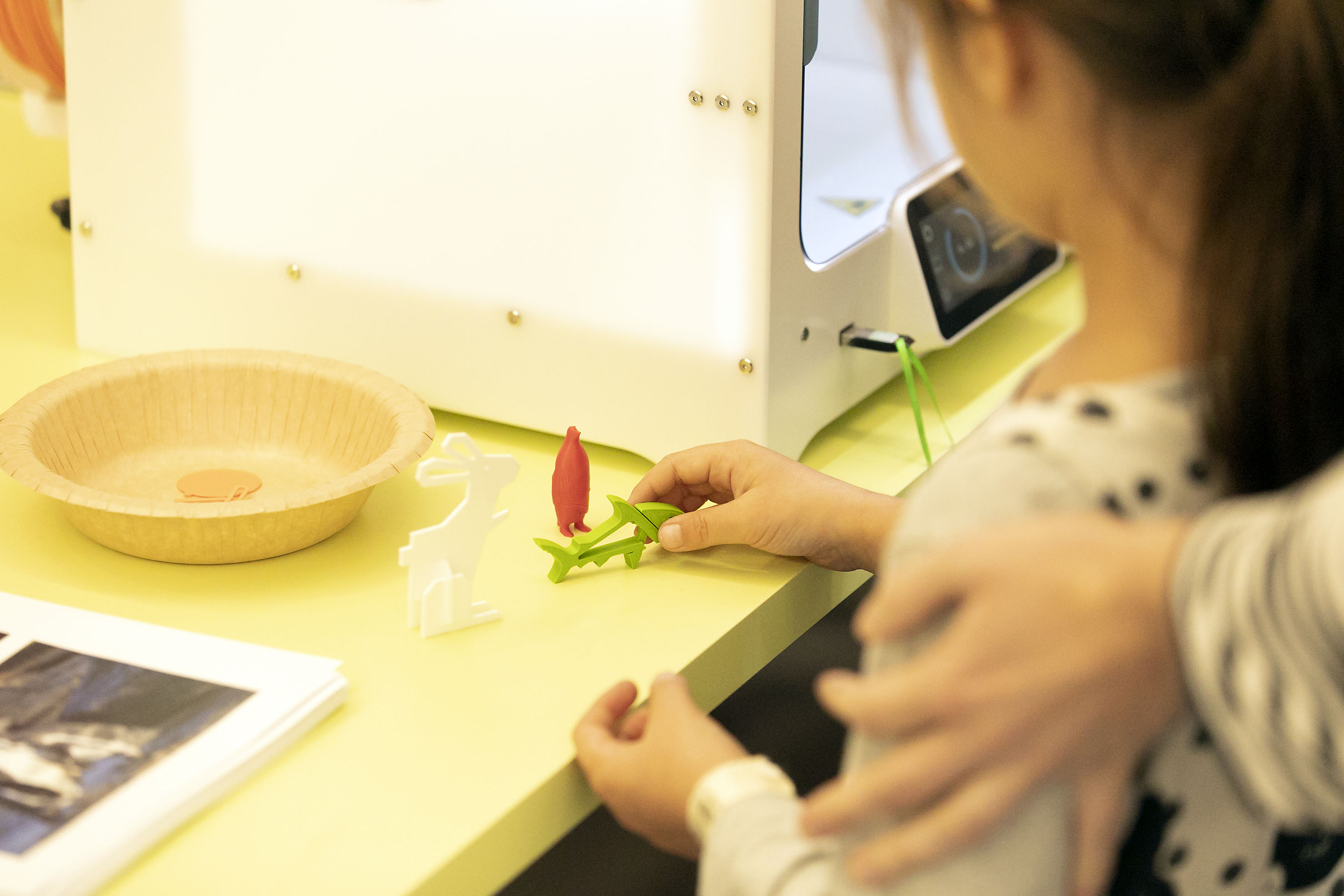 Ein Kind hat Tiere aus einem 3D-Drucker gestaltet