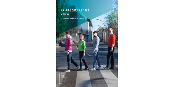 Vier Menschen, die mit Laptops über einen Zebrastreifen laufen.