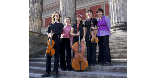 Foto von einer Gruppe von Frauen mit Musikinstrumenten auf einer Treppe.