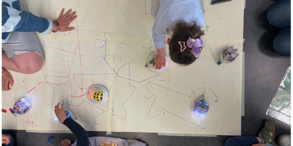Foto Draufansicht von Kindern, die auf einem Papier mit Linien mit Robotern spielen